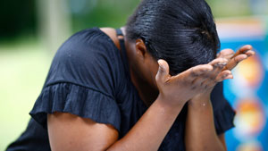 Woman leaning over holding face in her hands